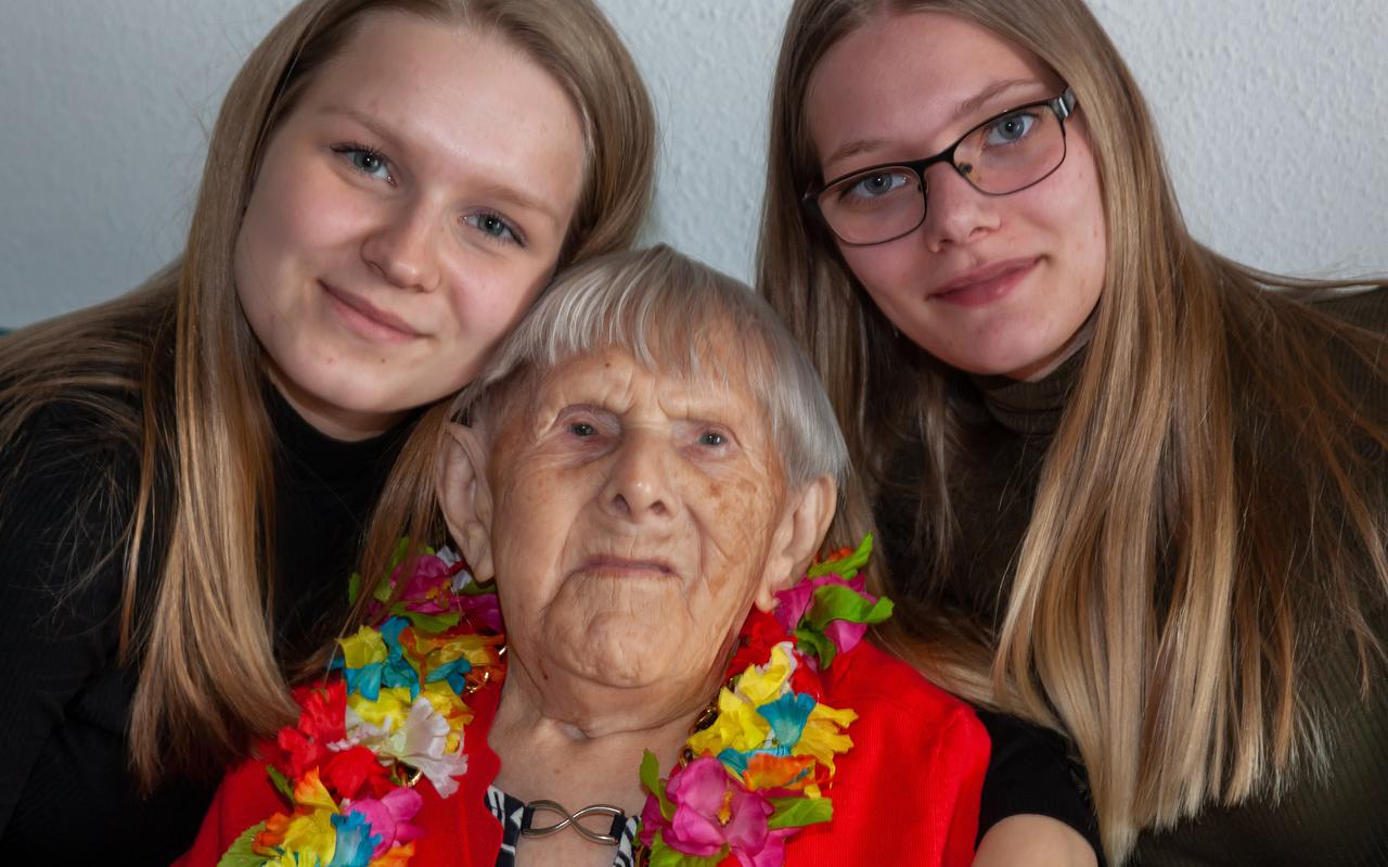 Jacoba IJmker-Benjamins (104) wordt geknuffeld door haar achterkleinkinderen Jasmijn (links) en Samantha.