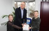 Niels Vos kreeg samen met zijn zusje Eva de iPad uitgereikt door Herman Idema. Foto: VPB-Emmen