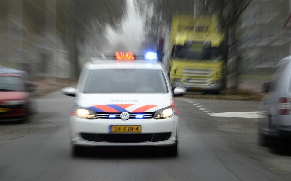 Foto ter illustratie. Een politieauto onderweg met sirene en zwaailicht. 