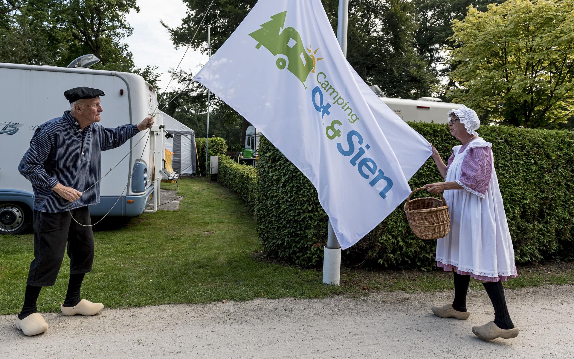 Wieb en Geertje, Ot en Sien, laten de vlag met het nieuwe logo zien. De camping wil vernieuwen, maar daarvoor is duidelijkheid van de gemeente nodig.