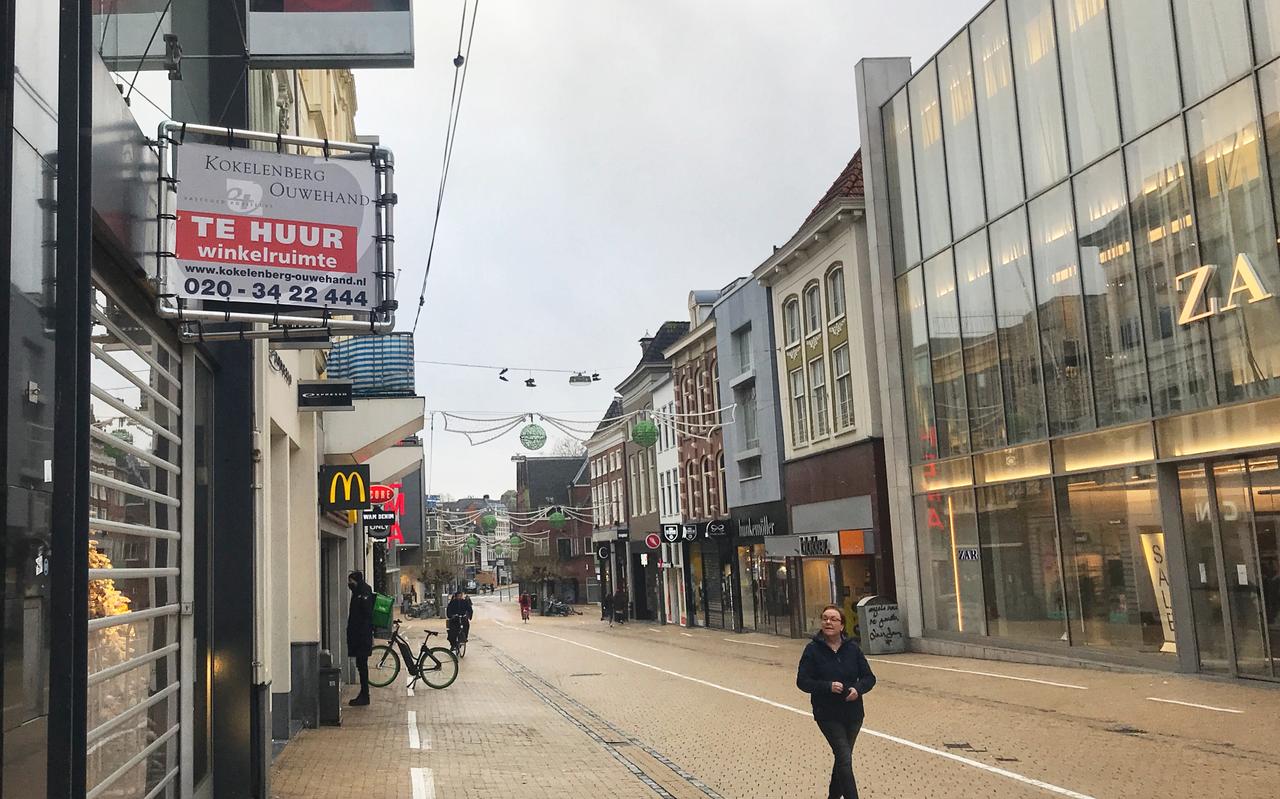 Enkele wandelaars stiefelen door de lege Herestraat. In de grootste winkelstraat van de provincie Groningen staan her en der al wat panden leeg. Enkele wandelaars stiefelen door de lege Herestraat. In de grootste winkelstraat van de provincie Groningen staan her en der al wat panden leeg.