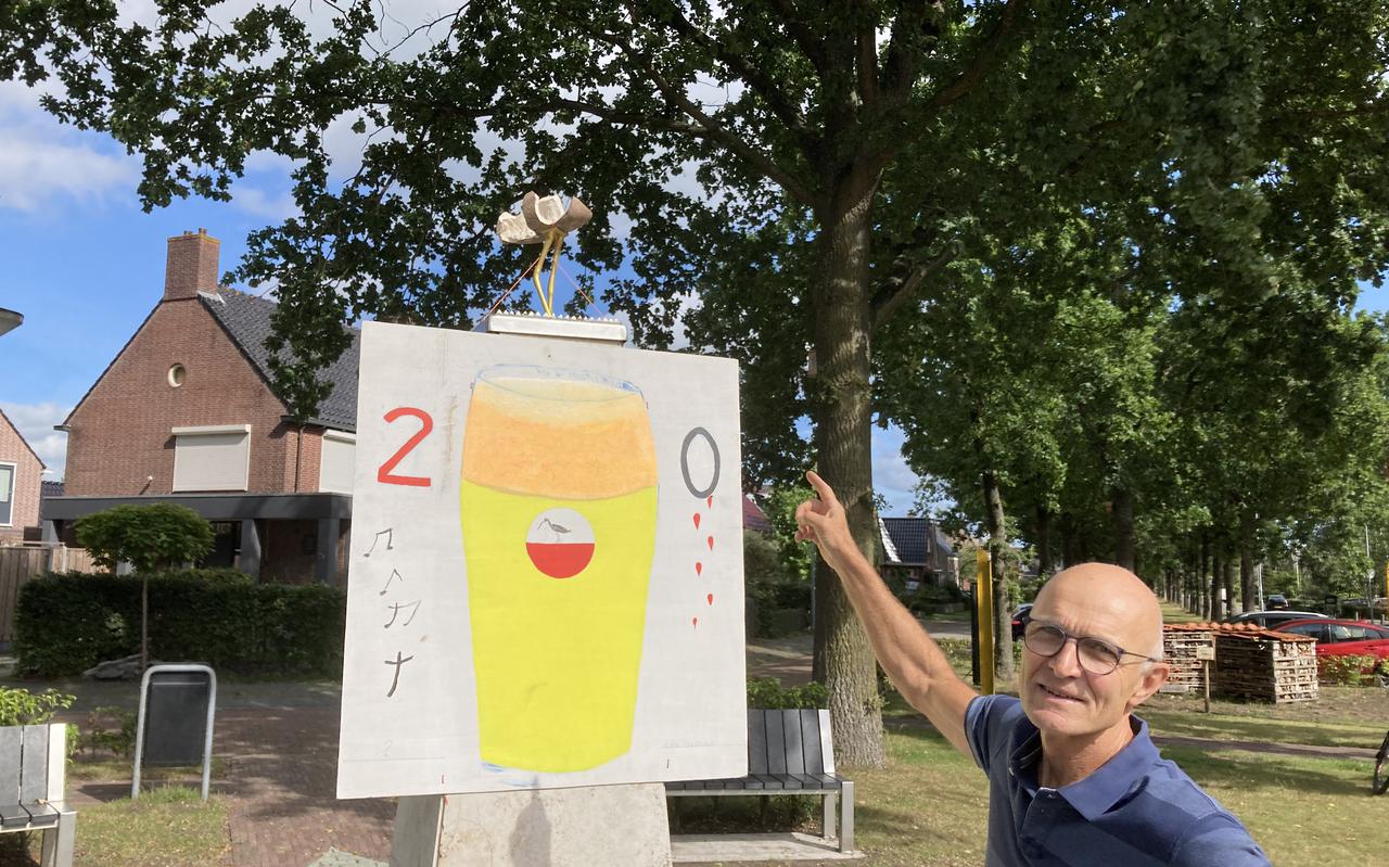 Kunstenaar Klaas Duursma - bij het protestbord - wijst naar het vernielde weidevogelkunstwerk in het centrum van De Wilp.