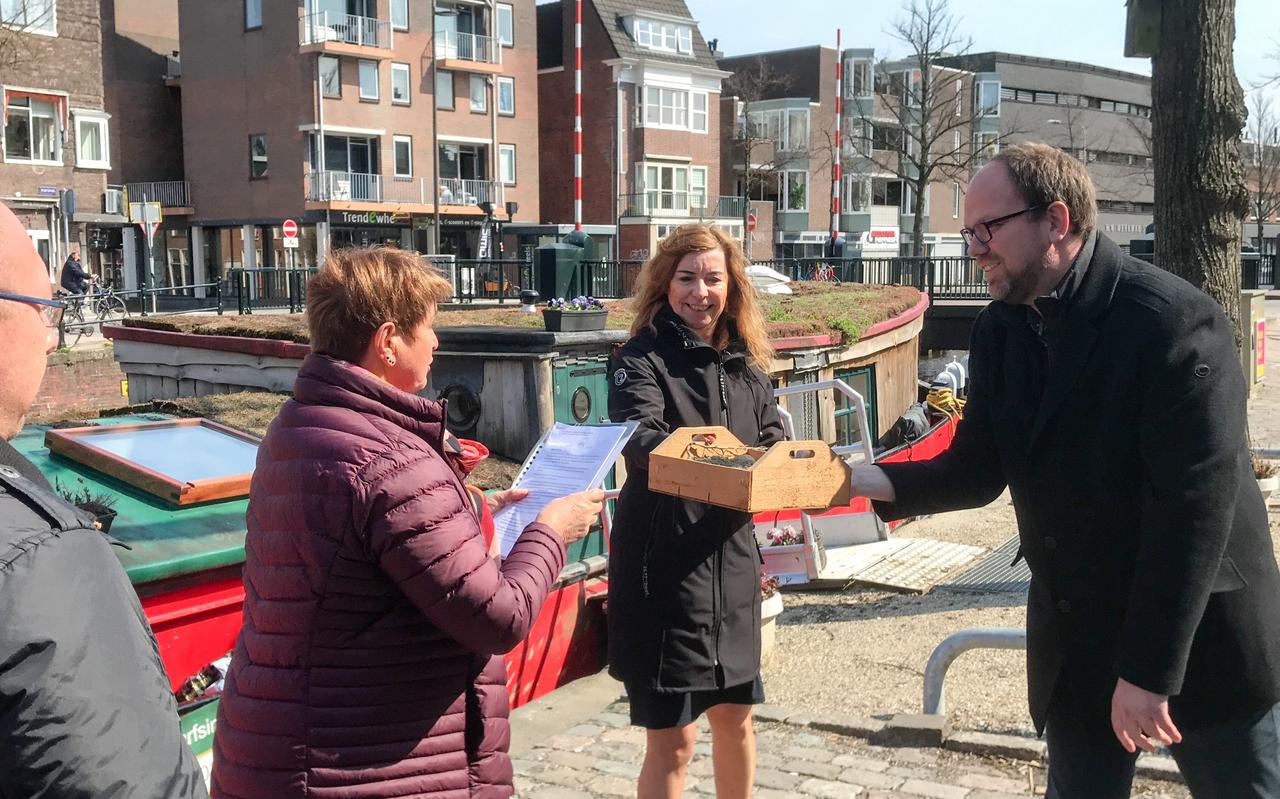 Etty Meijer leest de petitie voor en biedt ondertussen gedeputeerde Mirjam Wulfse en wethouder Eltjo Dijkhuis (rechts) alvast een bakje met kleigrond en pootaardappelen aan, namens 88 huishoudens uit Oudeschip en omgeving. Helemaal links: medebewoner Ronald Bultena. Etty Meijer leest de petitie voor en biedt ondertussen gedeputeerde Mirjam Wulfse en wethouder Eltjo Dijkhuis (rechts) alvast een bakje met kleigrond en pootaardappelen aan, namens 88 huishoudens uit Oudeschip en omgeving. Helemaal links: medebewoner Ronald Bultena.