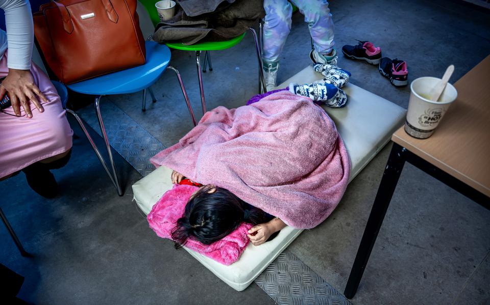 Een meisje slaapt op een matrasje op de grond in een tijdelijke container in de nachtopvang bij het aanmeldcentrum in Ter Apel. het is zo vol dat asielzoekers niet op een normale manier kunnen worden opgevangen. Doorstroom naar andere gemeenten is er te weinig. 