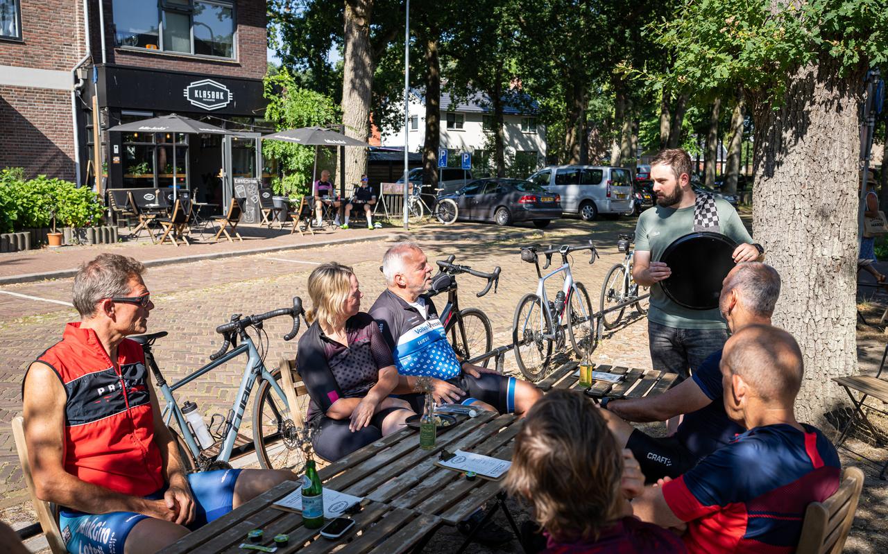 Eigenaar Mark Boersema in gesprek met een groep wielrenners op het terras van Fietscaffee Klasbak in Zuidlaren.
