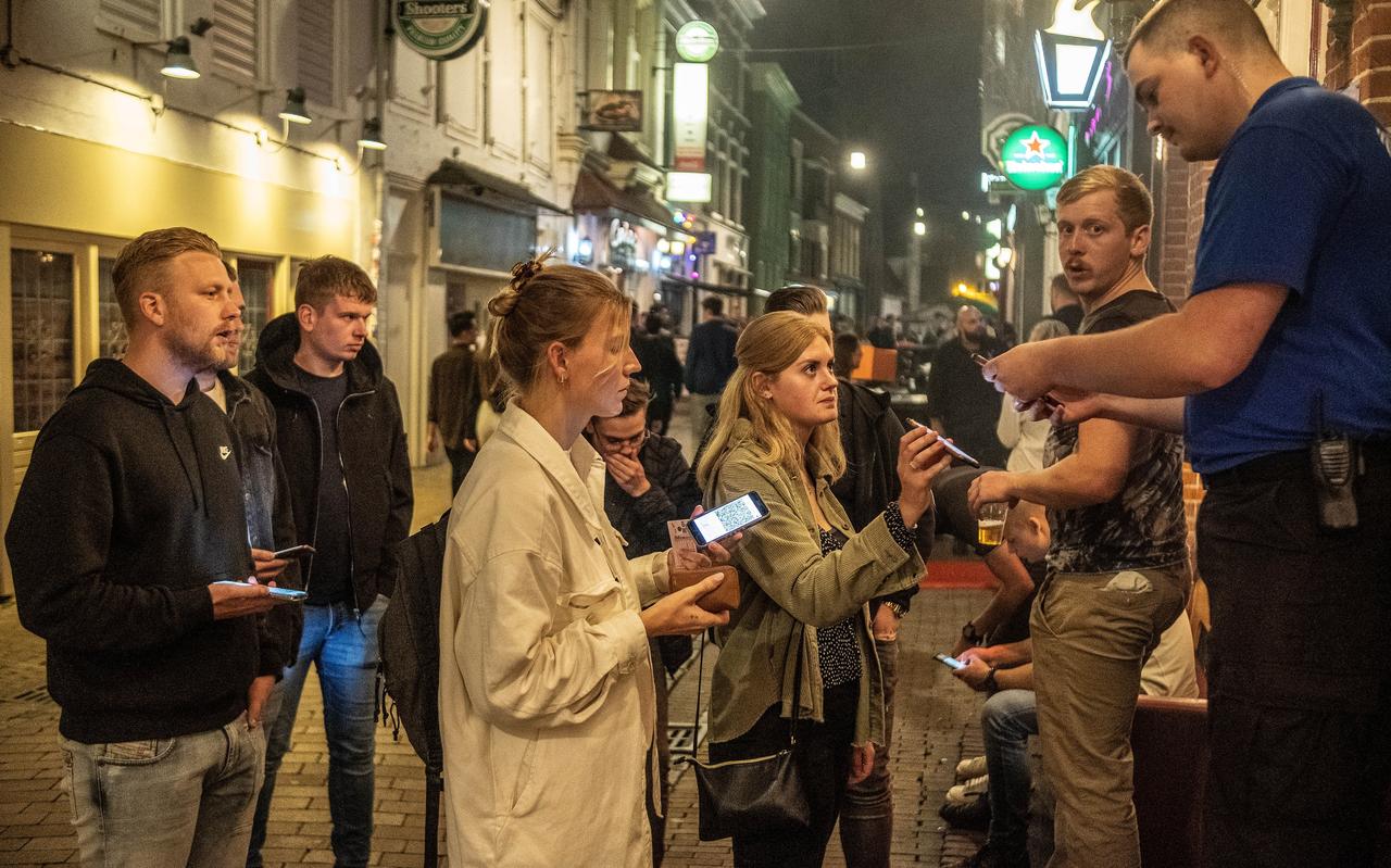 Nick Niezen checkt de QR-code en legitimatie van bezoekers voor de deur van Het Feest in de Peperstraat. Nick Niezen checkt de QR-code en legitimatie van bezoekers voor de deur van Het Feest in de Peperstraat.