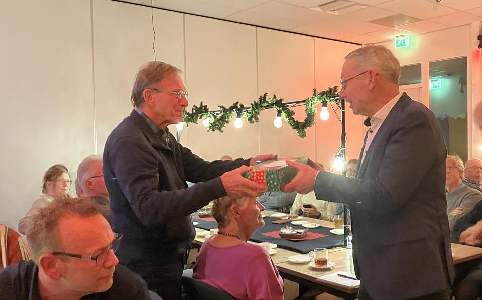 Wethouder Jan Schipper (r) verrast Wim van der Lelie met het eerste pakket.