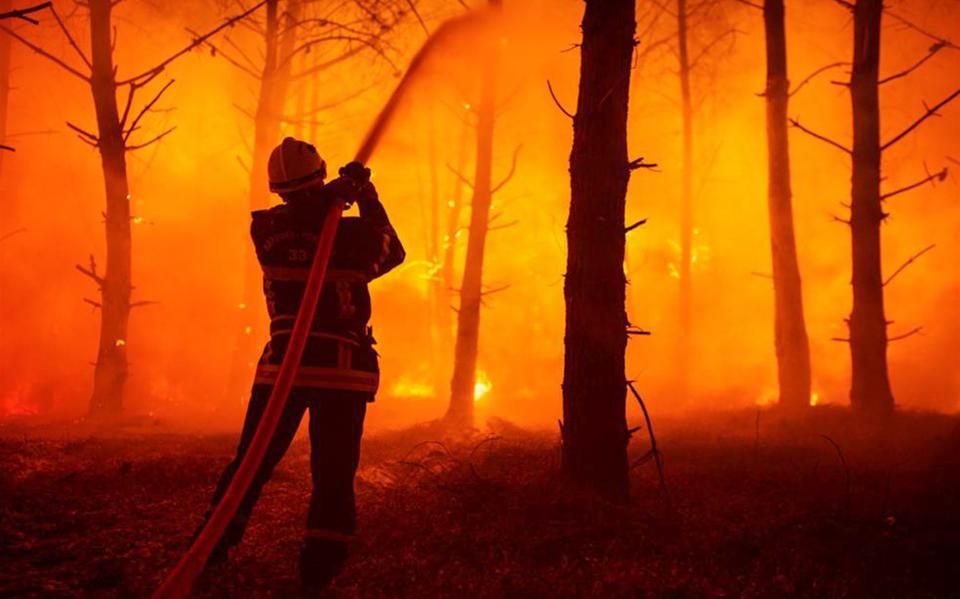 Een brandweerman probeert een bosbrand in Frankrijk te blussen.