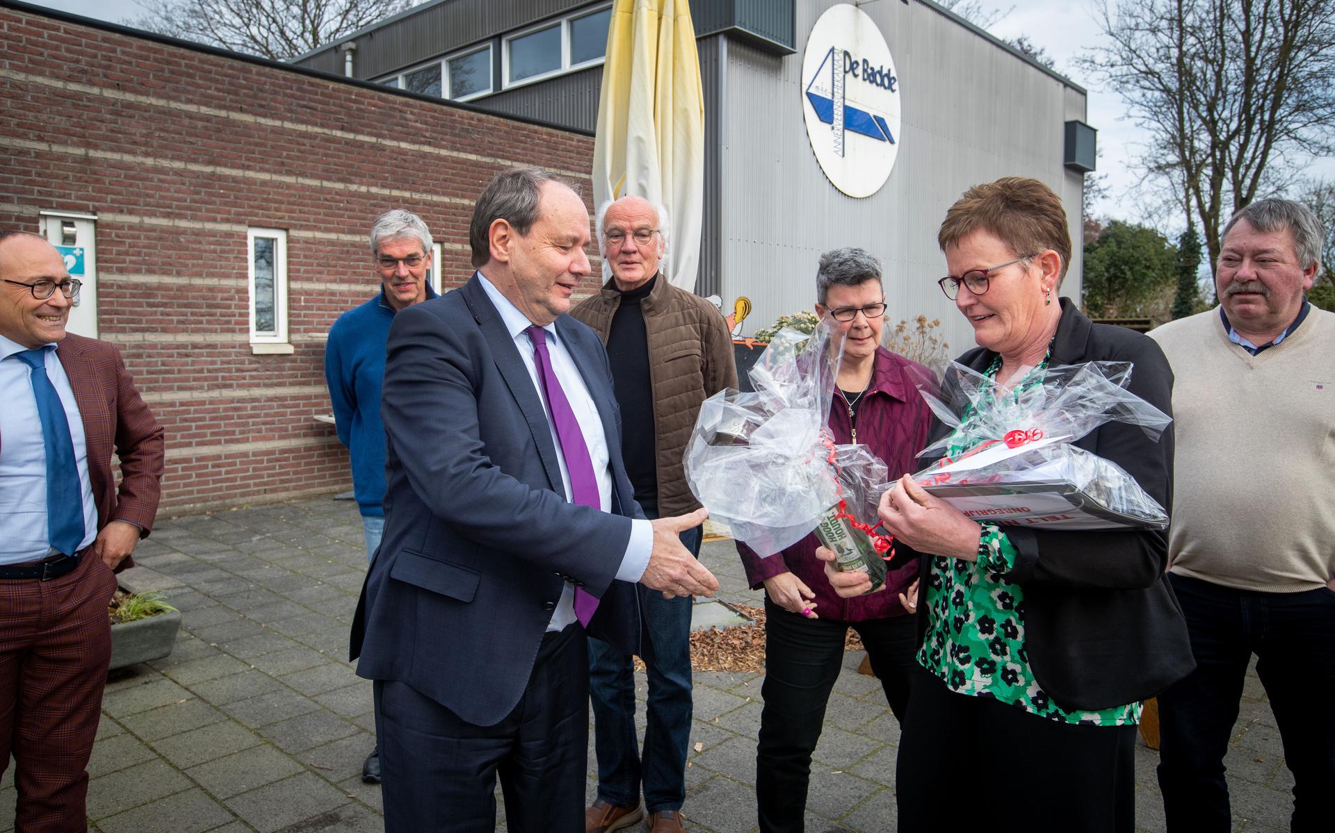Gemeenteraadslid Ina Oortwijn biedt staatssecretaris Hans Vijlbrief een fles jenever, turf en een map met handtekeningen van bezorgde inwoners aan. Links burgemeester Anno Wietze Hiemstra.