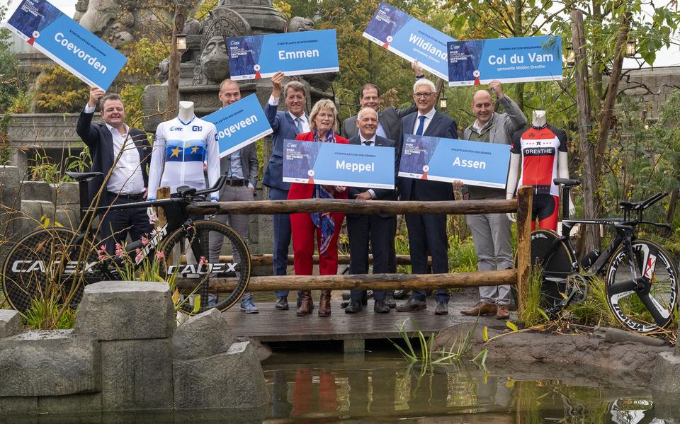 Burgemeesters en andere betrokkenen houden de toegewezen startplaatsbordjes enthousiast omhoog.