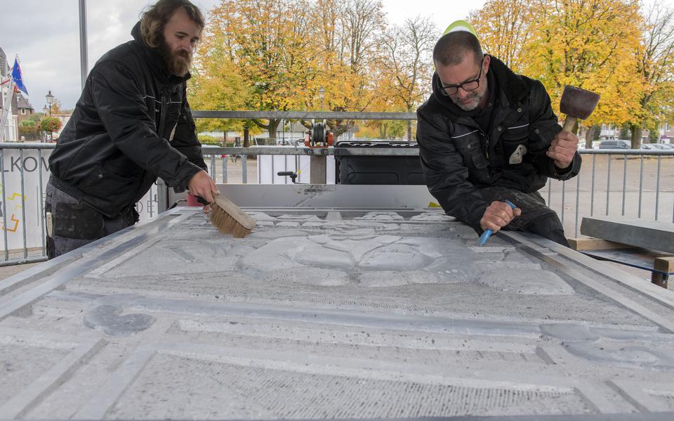 Peter van den Brink (links) en Tom Lamers leggen de laatste hand aan de gravure die zaterdag bij het historische pand van Kapper & Zo aan de Bentheimerstraat  komt te staan. 