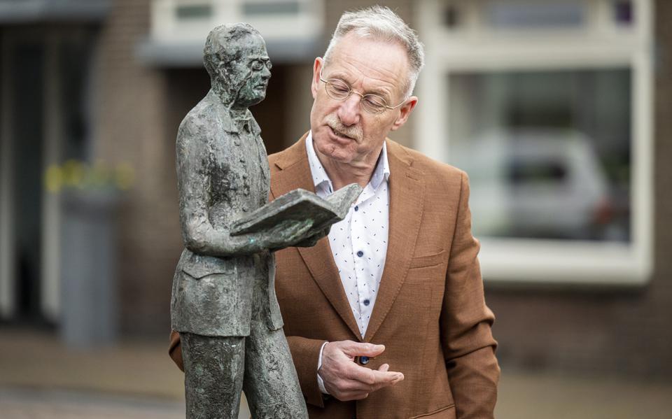 Henk Nijkeuter bij het beeld van Roel Reijntjes in Beilen, waarbij de Drentse dichter kijkt naar zijn ouderlijke woning.