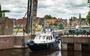 Een bootje vaart door het Stadskanaal in Musselkanaal, door achterstallig onderhoud zijn er steeds meer routes onbevaarbaar.