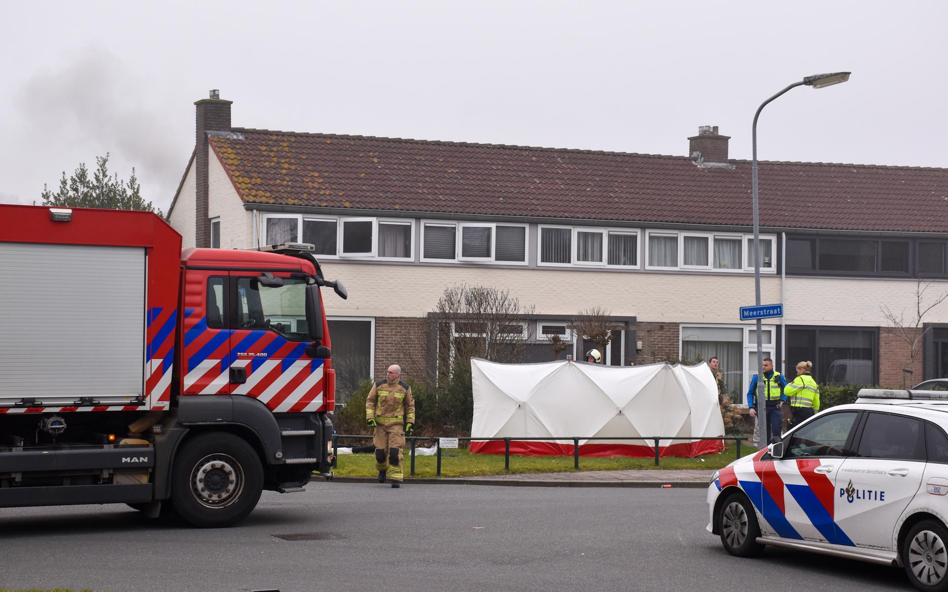 In de Meerstraat in Emmen woedt brand in een woning. Een slachtoffer ligt voor de woning en de brandweer heeft zichtschermen geplaatst. 