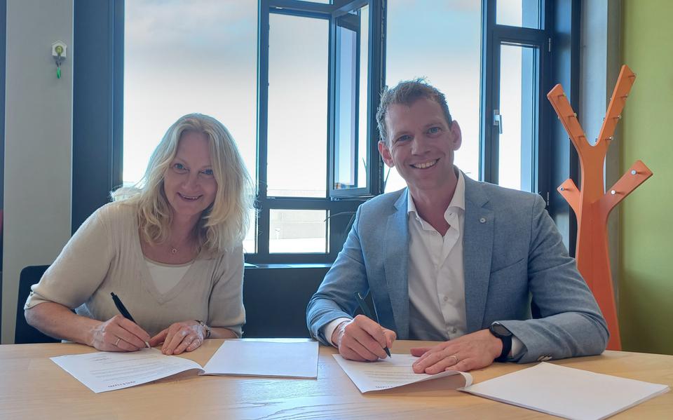 Directeur-bestuurder Melanie Maatman van Actium en directeur Bart Pigge van Dura Vermeer zetten hun handtekening onder het plan voor de bouw van 32 huurwoningen in Assen.