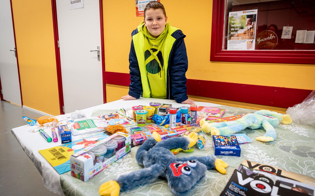 Linus (9) bij de cadeautjes die hij met zijn moeder inzamelde voor de voedselbank in Roden. 