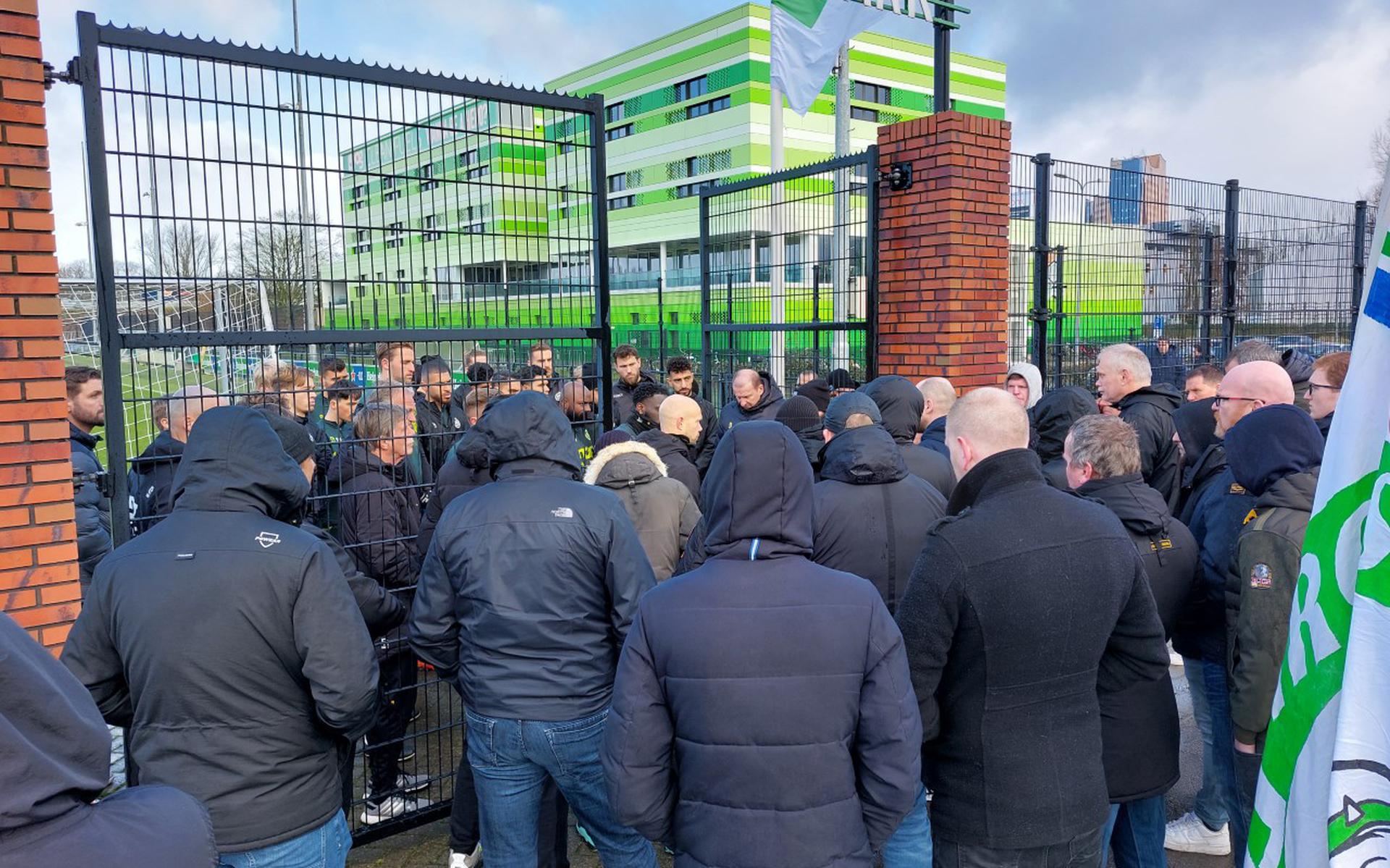 Zo'n 50 supporters meldden zich vrijdag bij het trainingsveld van FC Groningen. Trainer Dennis van der Ree (midden) en zijn selectie en staf luisteren en praten met ze.