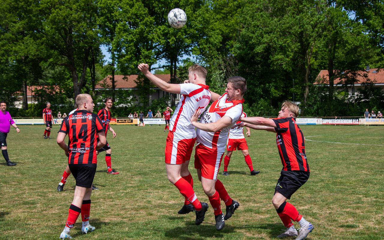 Heiligerlee-spelers Sander Dreijer en Niels Eden (midden) in actie in een wedstrijd in de reguliere competitie, op 15 mei tegen het als tweede gefinishte PJC.