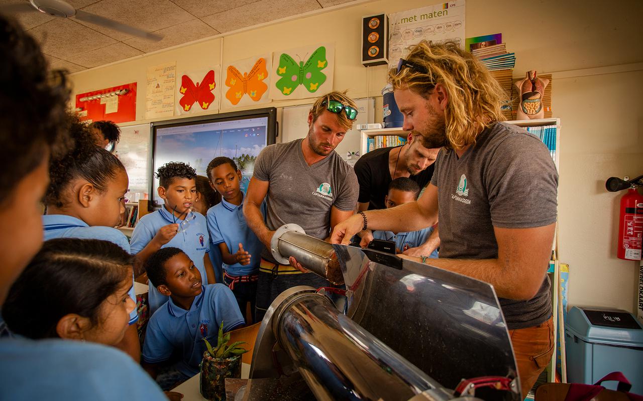 Niels Tammeling en Tjerk Zweers geven schoolkinderen op Tahiti uitleg over de recycling van plastic. 