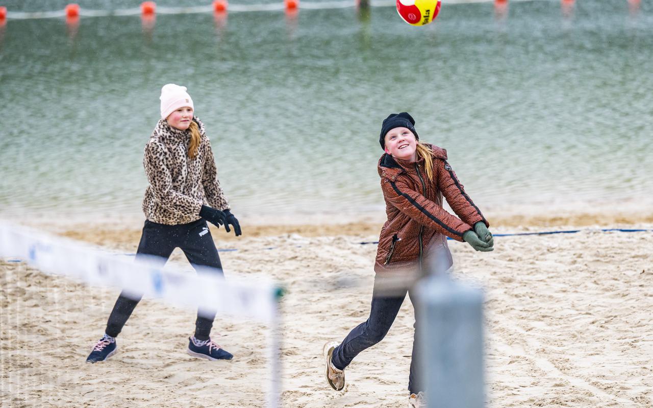Bij Baggelhuizerplas in Assen trotseren beachvolleyballers de regen en kou. 