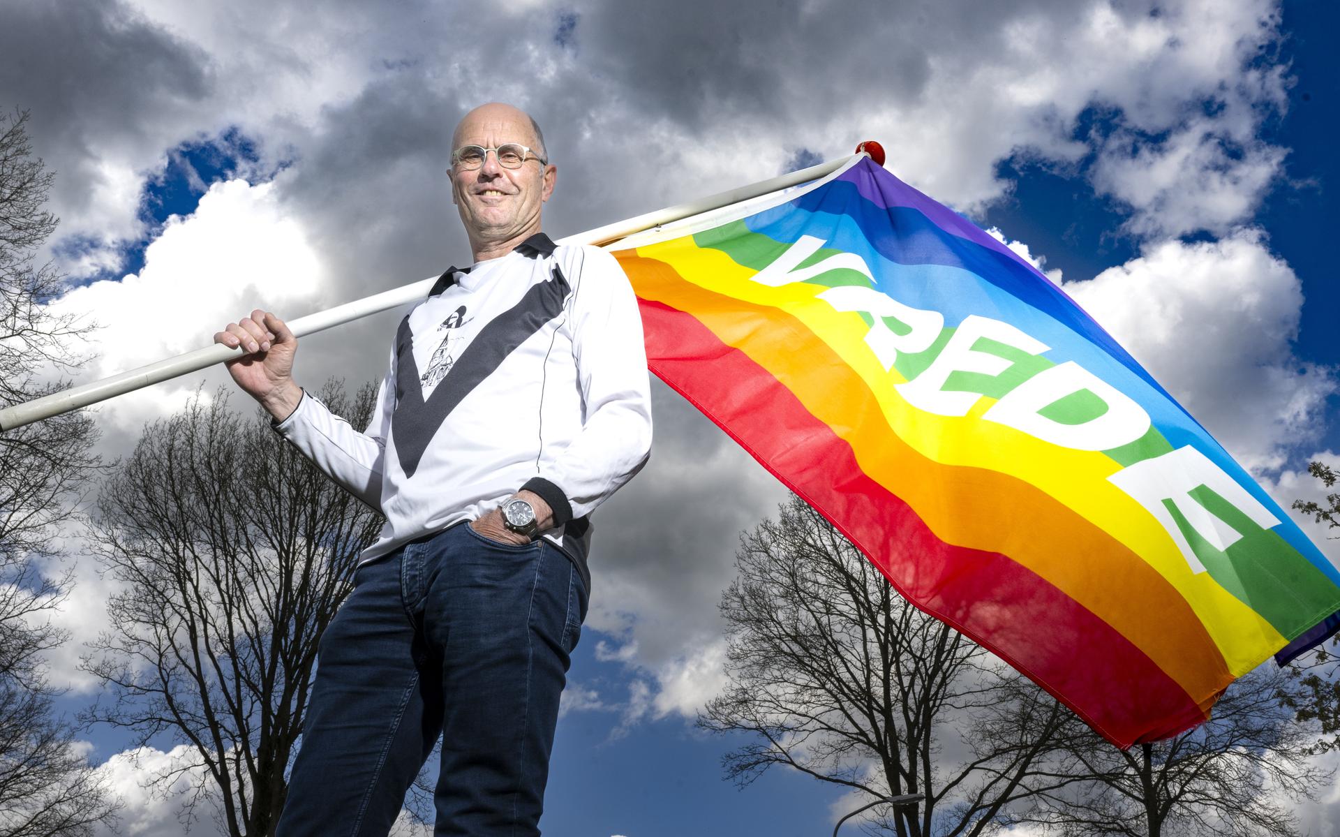 Jan Bos, dominee uit Rolde, neemt afscheid. Hier met zijn vredesvlag en het shirt dat hij als afscheidscadeau kreeg van VV Rolder Boys.