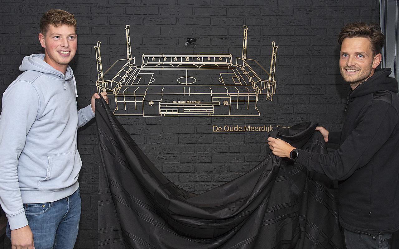 De broers Koen (links) en Anne Dijk met de door hun gemaakte goudkleurige geprinte afbeelding van het FC Emmen-stadion.