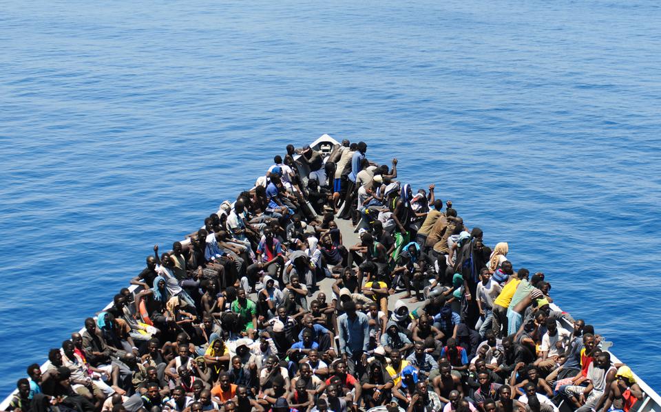 Vluchtelingen op een propvolle boot op de Middellandse Zee. 