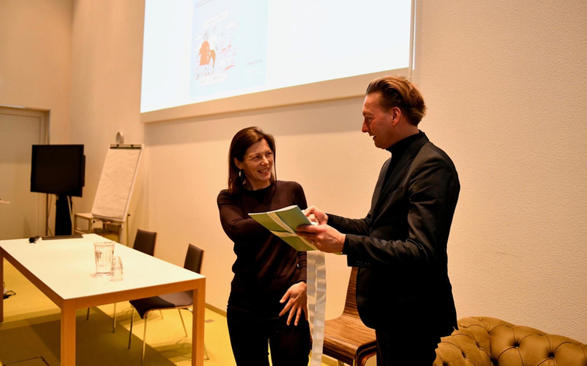 Zorgmanager Wilja Strating van Menzis overhandigt het rapport aan gedeputeerde Tjeerd van Dekken. Foto: Provincie Groningen