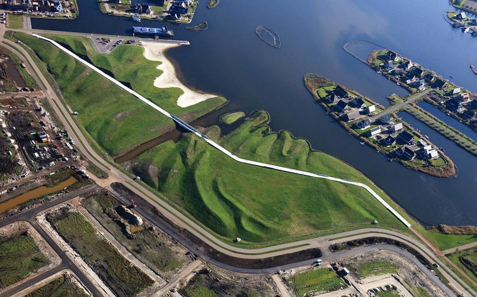 Landschapskunst in Meerstad: dwars door het nieuwe landartpark aan de oevers van het Woldmeer kronkelt een witbetonnen fietspad ,,als een kettingsnoer door het landschap''.   