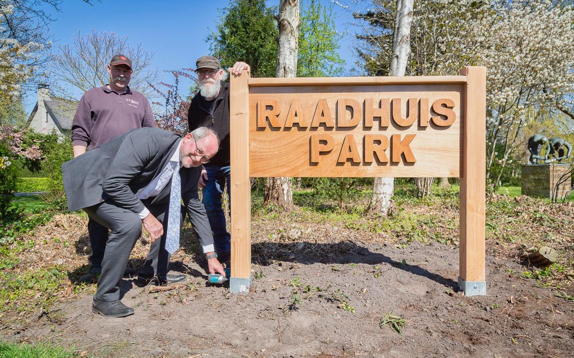 Burgemeester Karel Loohuis schroeft het laatste bord met daarop de nieuwe naam van het park in de verzinkte paalhouder.