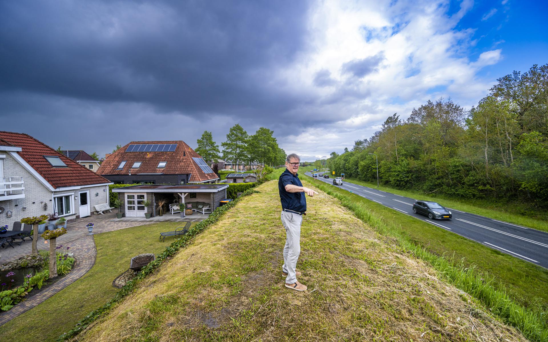 Minno Nicolai op de geluidswal achter zijn huis. Links in beeld zijn huis, rechts in beeld de weg langs Kloosterveen die de gemeente wil verdubbelen. 
