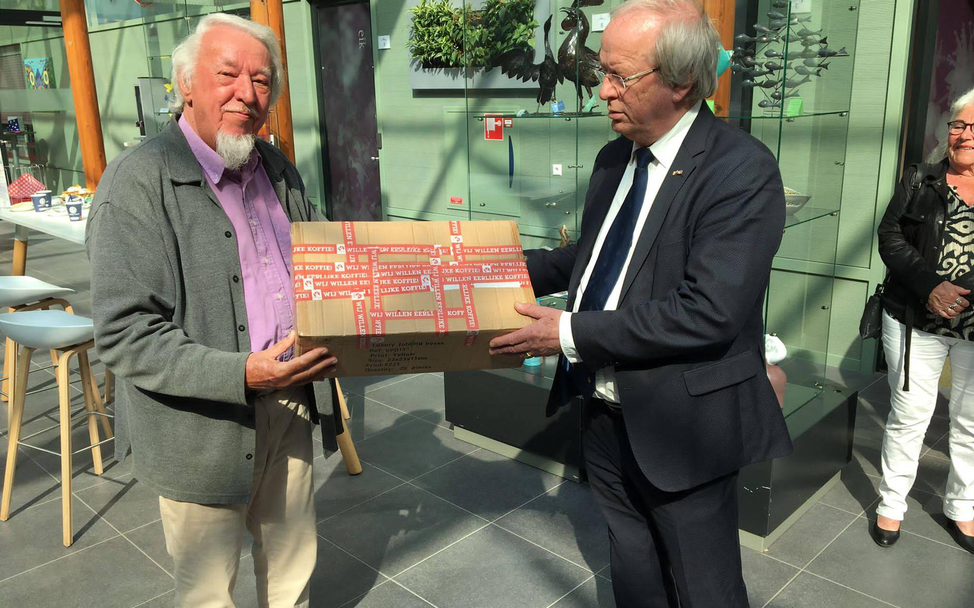 Voorzitter Jan Langenkamp overhandigt de cadeaudoos aan burgemeester Rikus Jager.