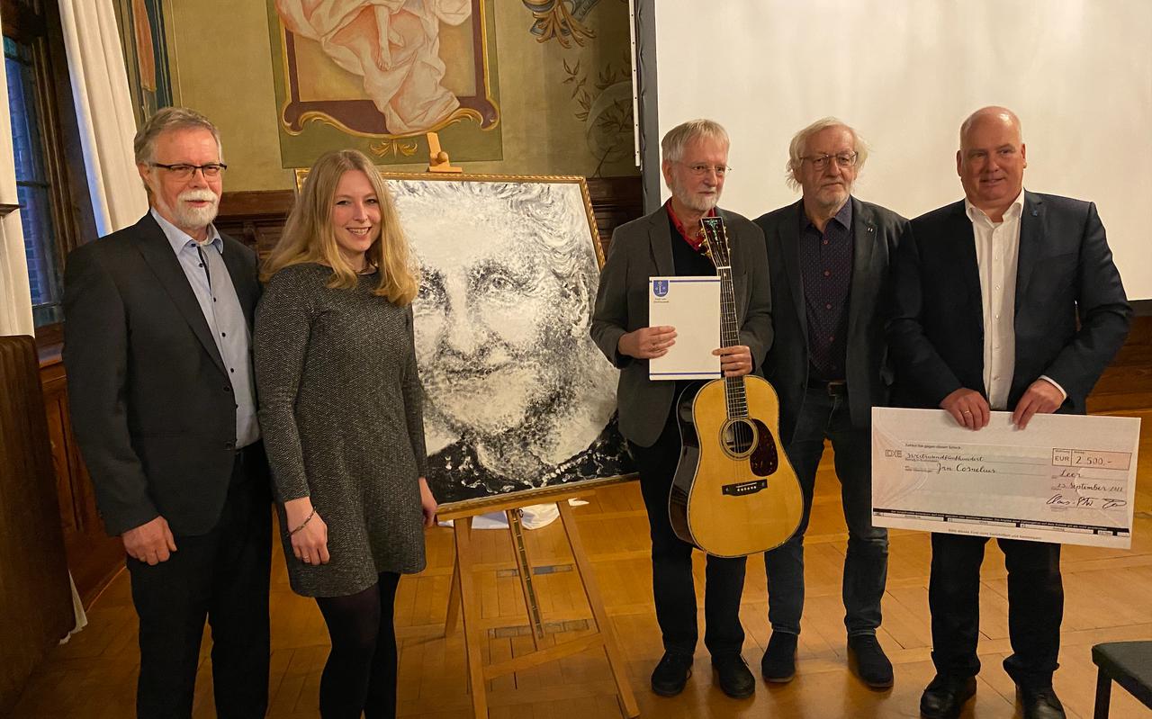 Jan Cornelius (met gitaar, naast het portret van Wilhelmine Siefkes) kreeg de prijs van de burgemeester (rechts) en de juryleden)