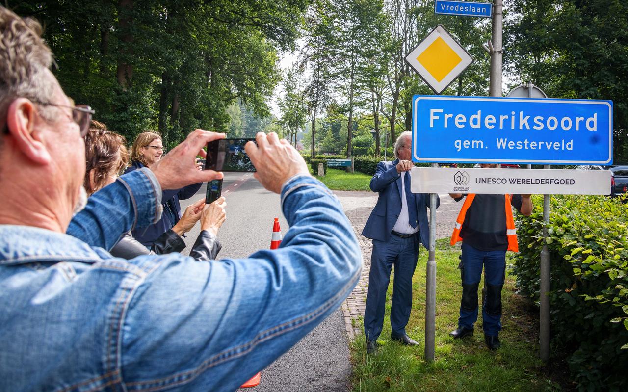 Burgemeester Jager hangt het bordje van Unesco onder het plaatsnaambord. Burgemeester Jager hangt het bordje van Unesco onder het plaatsnaambord.