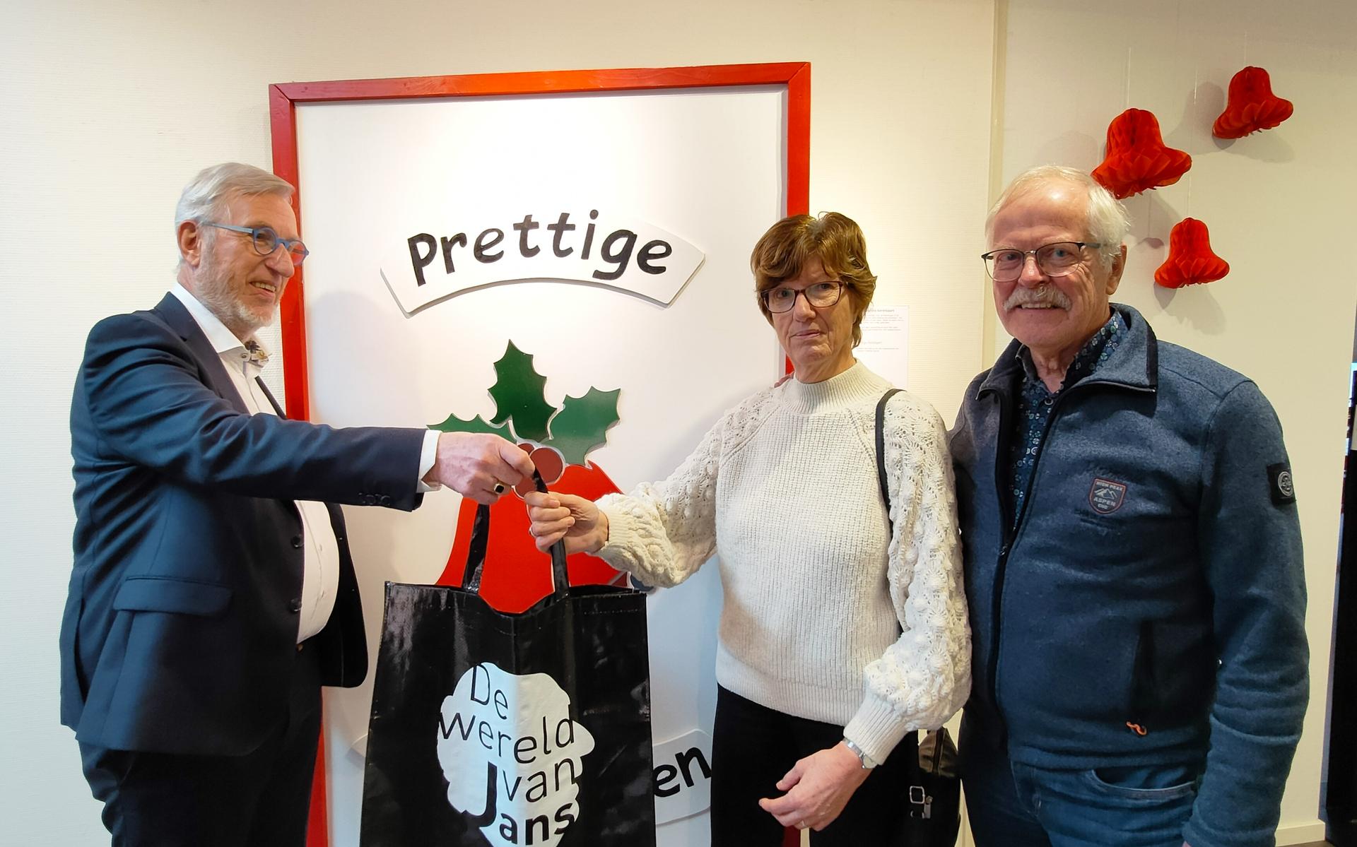 Voorzitter Hank Peters overhandigt een goodiebag aan Janny Warringa.