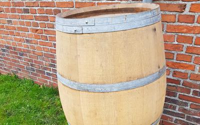 Een houten vat doet prima dienst als regenton.