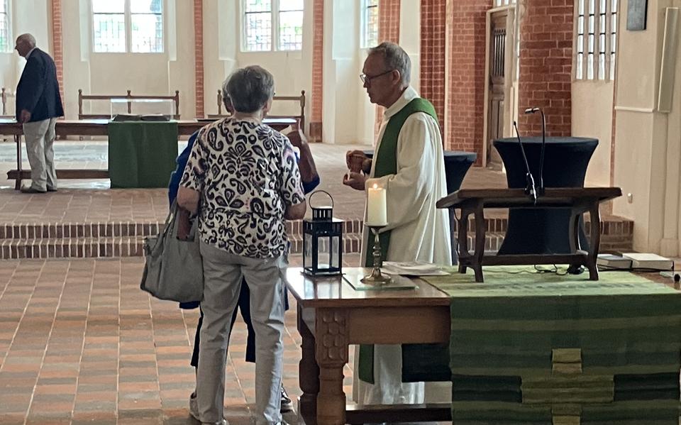Dominee Tjalling Huisman praat na de kerkdienst op Groningenzondag na met bezoekers.