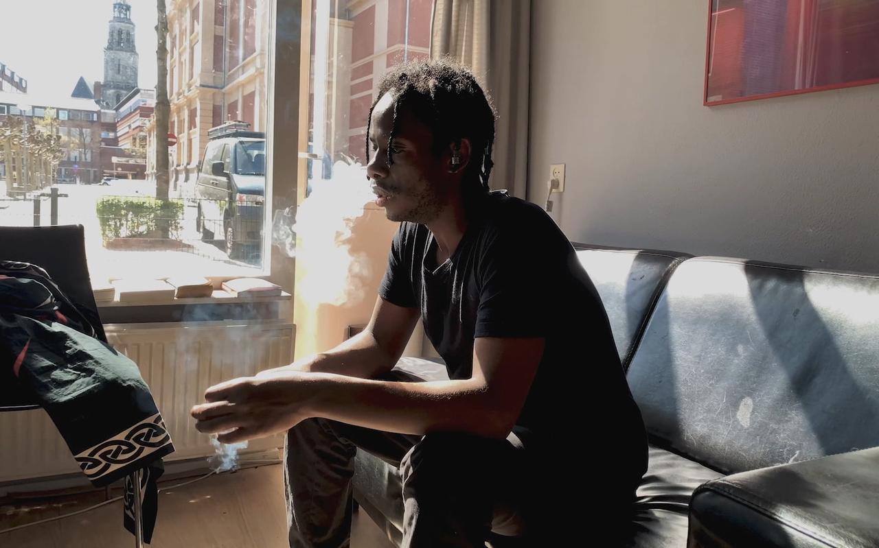 Mulu zit in zijn huis naast de Stadsschouwburg in Groningen. Still uit de documentaire-serie 'Verdoofd'. Mulu zit in zijn huis naast de Stadsschouwburg in Groningen. Still uit de documentaire-serie 'Verdoofd'.