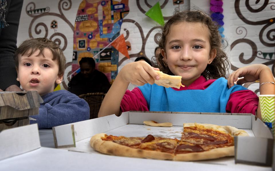 Op hun afscheidsavond trakteren de beheerders van de gemeente Groningen op pizza voordat ze de opvang aan het Damsterdiep overdragen aan het COA.