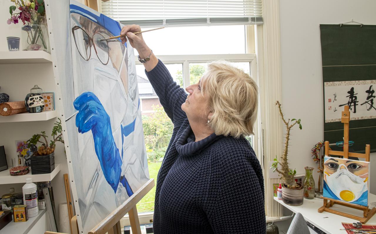 Jolanda Schoenmaker bezig met een portret van een verpleegkundige. 'Ik zag alleen maar smurfen, verpleging en schoonmaaksters in blauwgroene pakken, rubberen handschoenen en maskers. Alleen de ogen waren zichtbaar, vaak ook nog verstopt achter een grote bril. En schoenen.' Jolanda Schoenmaker bezig met een portret van een verpleegkundige. 'Ik zag alleen maar smurfen, verpleging en schoonmaaksters in blauwgroene pakken, rubberen handschoenen en maskers. Alleen de ogen waren zichtbaar, vaak ook nog verstopt achter een grote bril. En schoenen.'