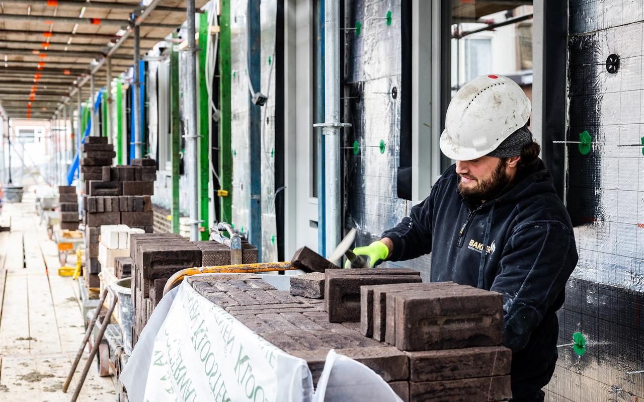 Een bouwvakker aan het werk bij een nieuwbouwproject. Een bouwvakker aan het werk bij een nieuwbouwproject.