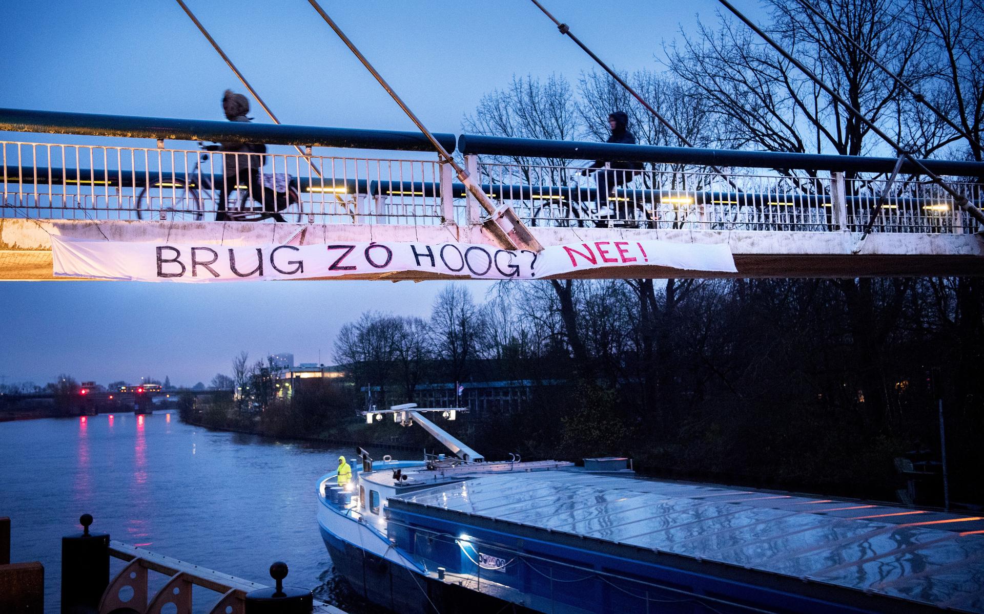 Een spandoek aan de Gerrit Krolbrug maakt duidelijk wat fietsers en omwonenden niet willen: net zo'n hoge brug als de huidige voetbrug.