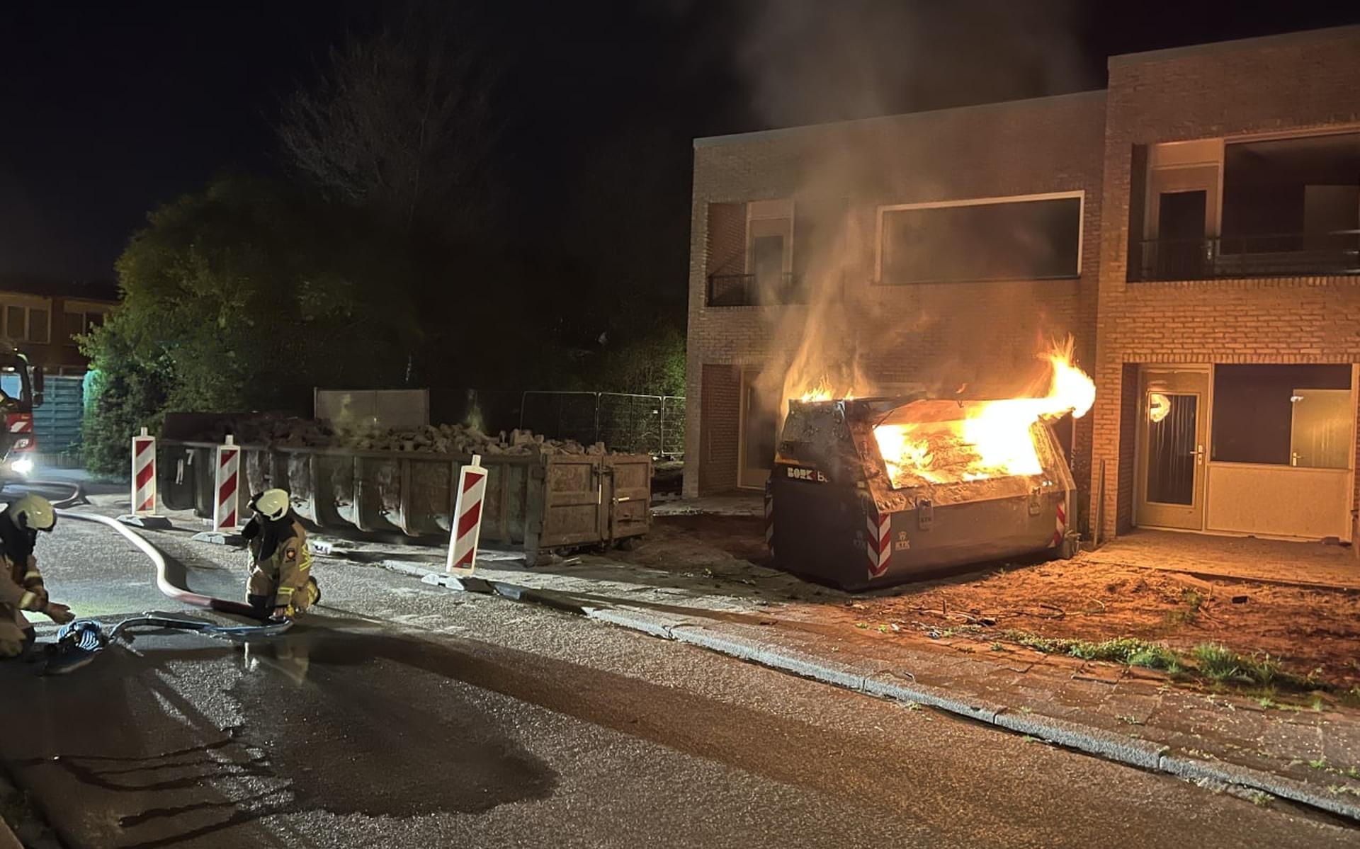 Vlammen slaan uit de bouwcontainer in de Eisenhouwerstraat.
