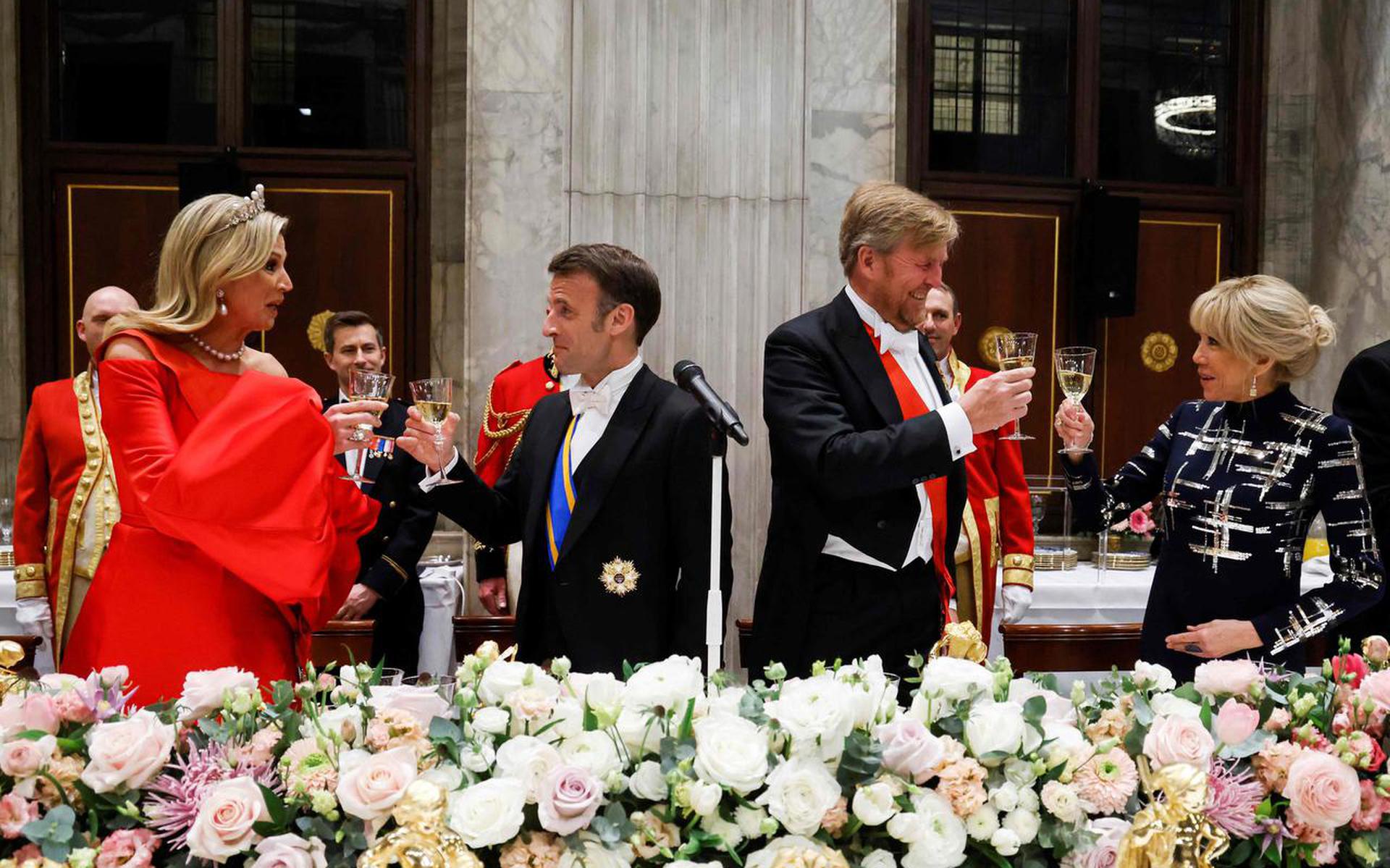 Koningin Máxima, president Emmanuel Macron, koning Willem-Alexander en Brigitte Macron brengen een toast uit op de onderlinge betrekkingen tussen Nederland en Frankrijk.