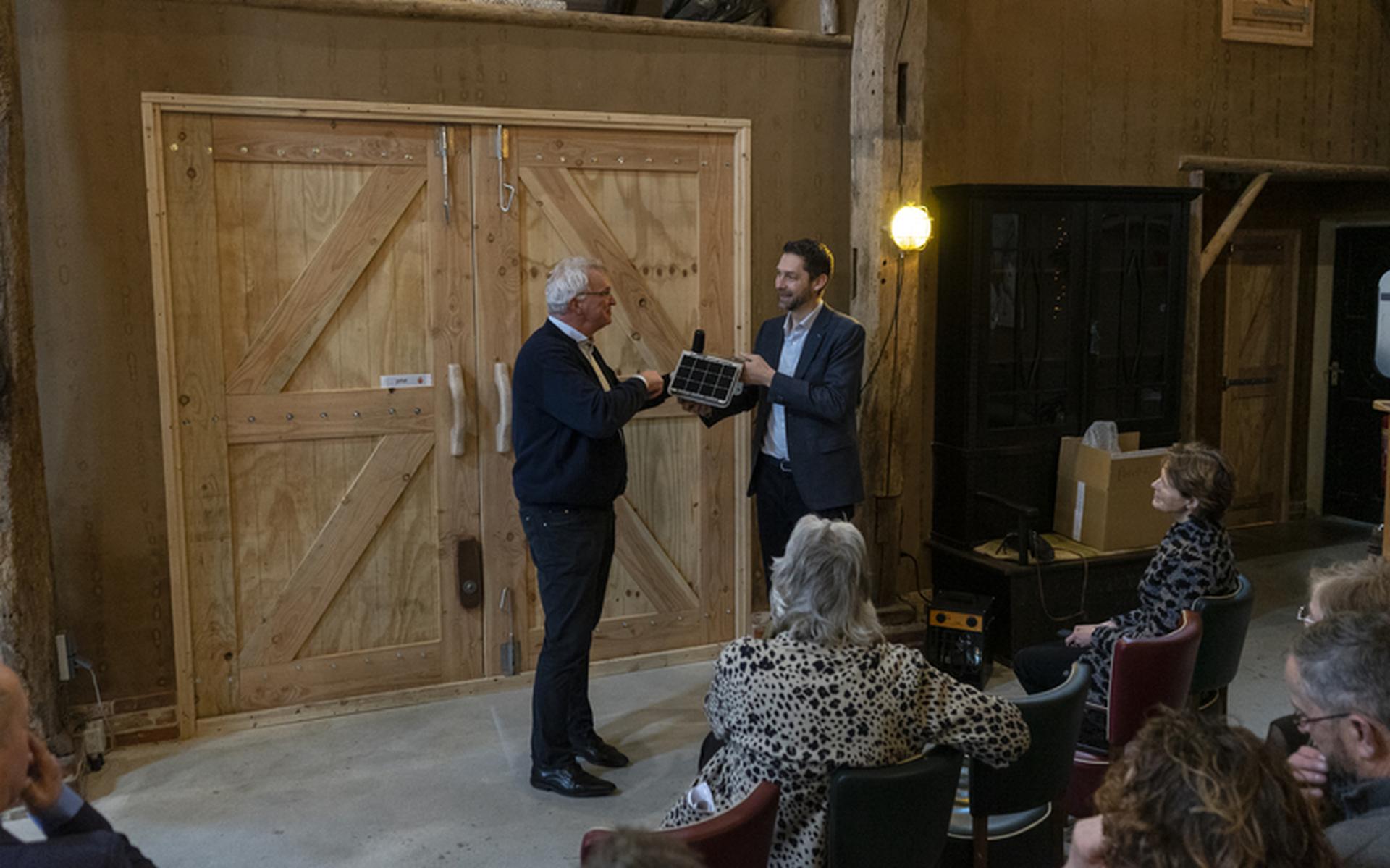 Johan Hamster krijgt symbolisch het laatste meetkastje overhandigd. Foto: Provincie Groningen