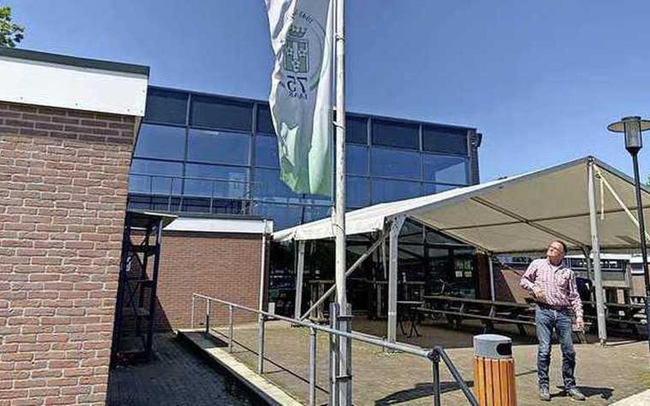 Een lid van voetbalclub SV Gramsbergen hijst de vlag halfstok. Een lid van voetbalclub SV Gramsbergen hijst de vlag halfstok.