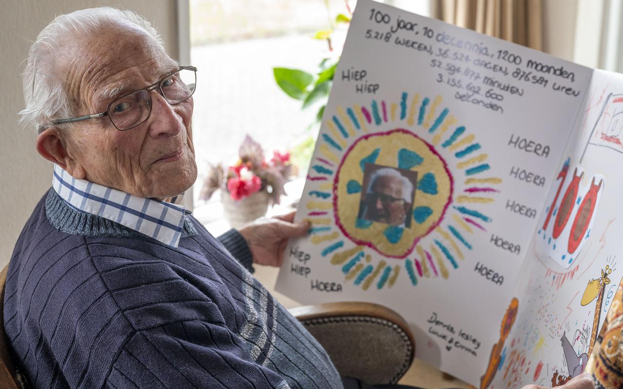 Andries Drenth met een enorme kaart die hij ontving vanwege zijn honderdste verjaardag.