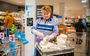 Een medewerkster van de Albert Heijn desinfcteert een winkelkarretje in de supermarkt. 