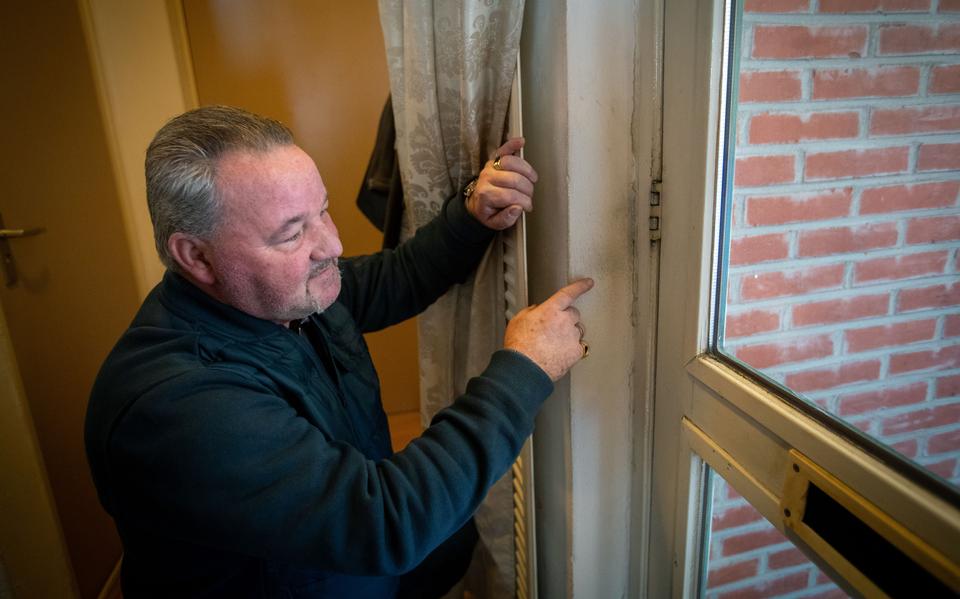 Een bewoner van de Oranjestraat in Stadskanaal wijst op schimmel naast zijn deur. De problemen spelen al jaren. 