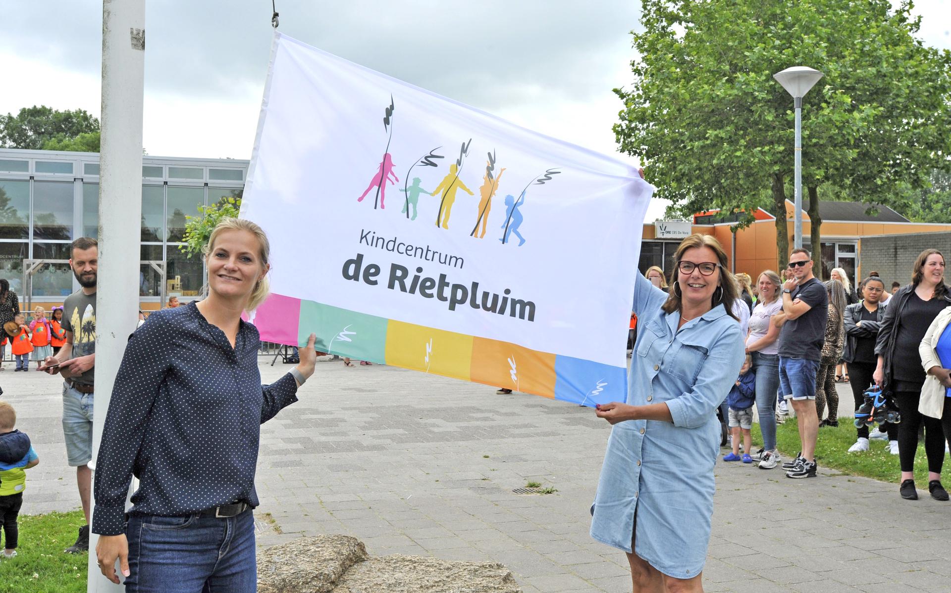 Marcelle Zuur (links) en Titia Bult hijsen de vlag met de nieuwe naam en het nieuwe logo.